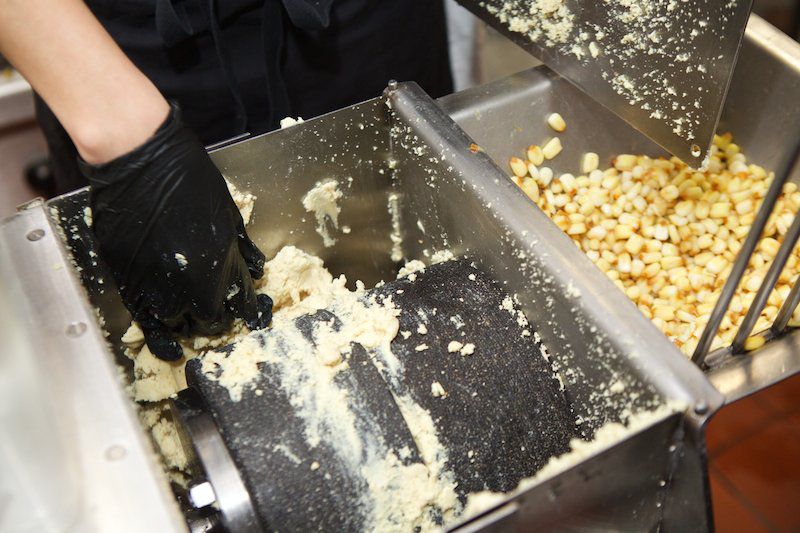 A stone grinder is used to pulverize the corn into masa<br>